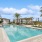 a pool with palm trees and buildings around it