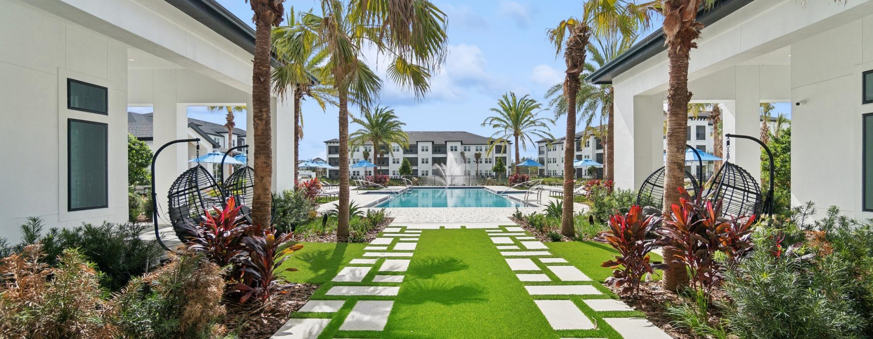a swimming pool with palm trees and a building